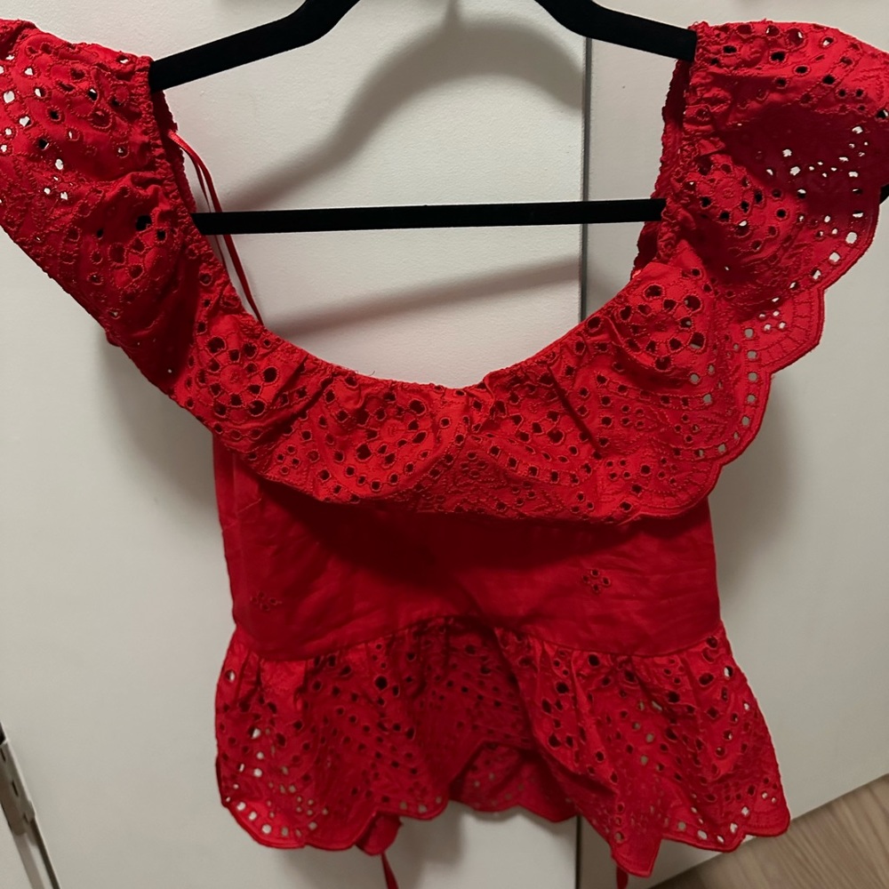 red top that is slightly cropped - short sleeves but fun lace pattern.